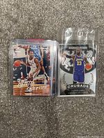 Photo of two NBA basketball cards in plastic protective sleeves showing Scotty Barnes and LeBron James cards.