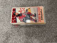 Photo showing the top card of a large stack, depicting hockey player John MacLean in a red New Jersey Devils uniform with a Power Play logo on the card.