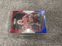 Photo of a single wrestling trading card inside a small plastic team bag featuring Dusty Rhodes in the 2021 Topps WWE series.