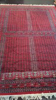 Full view of red geometric area rug laid on dark wood floor
