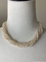 Front view of multi-strand twisted pearl necklace on display bust
