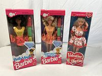Three boxed Barbie dolls side by side showing overall lot