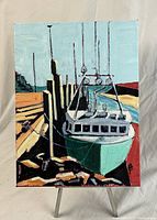Front view of the original oil painting showing a boat docked in harbour painted in bold colors on canvas, depicting water, dock pilings, and boat details.