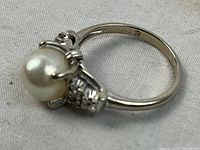 Close-up side view of ring showing pearl and diamond accents in 14k white gold setting