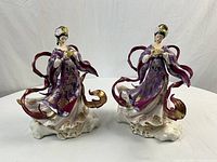 Front view showing both figurines on table with white backdrop