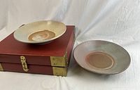 Two celadon dishes displayed next to closed gift box; shows scale and styling