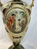 Front close-up showing detailed hand-painted classical figures in an oval frame with gold decorations on vase body.
