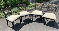 Four hand-carved Regency Era dining chairs arranged outdoors on pavement, showing full set and overall design and condition