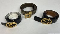 Three belts laid out side by side on white background