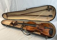 Open case showing violin inside with two bows stored in lid