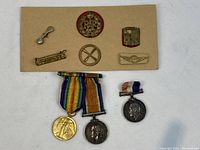 Overview of six insignia on board above three medals