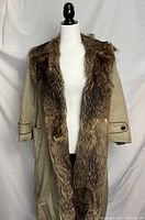 Front view of coat with fur-lined collar and open front, wooden toggle closure visible