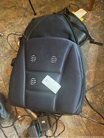Two black back massager cushions with visible massage nodes on the cushions. One cushion shown with a tag.