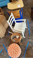 White-painted wooden child's rocking chair, two wooden foot stools (rooster painted and orange mosaic) visible from above