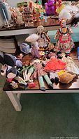 Photo showing multiple rag dolls, wooden Mickey Mouse, Betty Boop doll, and character memorabilia arranged on a table