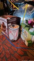 Photo showing Nostalgia ice cream machine box, glass jar, and painted tea chest and decor items on the floor