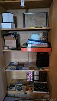 Wide shelving unit showing multiple trays, tiles, and boxes arranged on shelves.