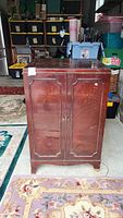 Front view of the vintage wooden cabinet housing the Zenith TV, showing double doors and polished dark wood finish.