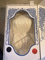 Wedding dress with lace and beading inside decorative storage box with clear viewing panel.