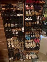 Overall view of two black shoe racks full of women's footwear in various styles.