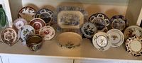 Full set of 17 vintage china pieces including plates and bowl displayed on shelf with stands.
