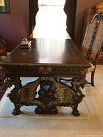 Frontal view of desk top and griffin base with inkwell and chair in background
