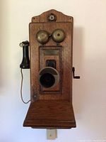 Full front view of oak wall telephone showing bells, mouthpiece, shelf and earpiece
