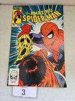Front cover of The Amazing Spider-Man #245 comic book showing Spider-Man and a person holding a mask, published by Marvel.