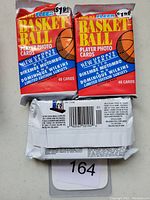 Three unopened jumbo packs of 1991 Fleer Basketball Player Photo Cards with clear labeling showing front, price stickers, and back barcode.