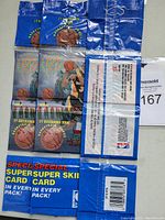 Three unopened rack packs of 1995 Topps Stadium Club basketball cards. Front packs show basketball and player graphics with text.