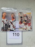 Front of two 1997 Sports Magazine promo cards featuring Wayne Gretzky and Mark Messier in New York Rangers uniforms, encased in plastic.