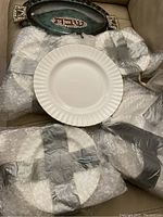 Bubble-wrapped pieces and fluted dinner plate on couch