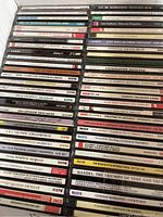 Stack of approximately 50 classical CDs showing mixed titles predominantly from the Naxos label featuring symphonies, concertos, and orchestral highlights.