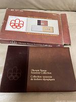 Outer sleeve packaging for Olympic Stamp Souvenir Collection in brown tone with Olympic rings logo.