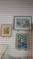 Image of three paintings including the two in the lot; shows placement and relative size on wall.