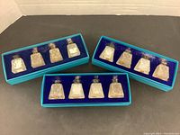 Three turquoise Birks boxes each with blue velvet lining, containing clear glass salt and pepper shakers in sets of two per box.
