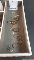 Tray overview showing bracelet, rings, charms and earrings