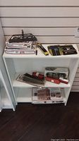 Shelf displaying multiple train set parts including bridge, tracks, and train cars