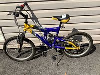 Side view of Bandito Infinity 6-speed children's bike with blue and yellow frame, black and yellow seat, dual suspension, and knobby tires.