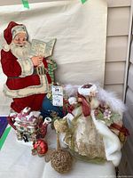 Wide view showing Fitz and Floyd teapot, vintage flocked Santa, angel tree topper, and two Christmas ornaments arranged together