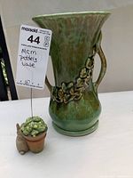 Front and side view of tall green glazed Mid Century Modern pottery vase with floral relief and two handles.