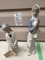 Both Rex and Tengra figurines seen side by side on a surface with tag showing description and lot number