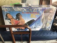 Box of AB Rocket exerciser showing branding and product name with images of the exerciser and people using it.