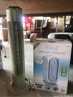 Photo of Ionic Breeze Quadra air purifier next to boxed Hamilton Beach TrueAir allergen reducer
