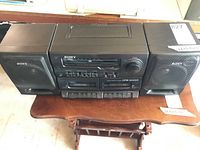 Front view of Sony CFS-W455 boom box with dual speakers on both sides placed on a small wooden table.
