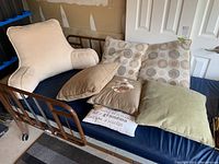 Overview of all six cushions on blue bed with metal frame