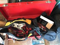 Open DeWalt tool bag showing vice grips, multiple red and black screwdriver handles, and a can of Gorilla Glue inside the red metal toolbox.