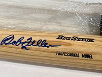 Close-up image showing the Bob Feller signature in blue ink along with printed text Big Stick and Professional Model on wooden bat surface.