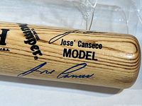 Close-up photo showing Jose Canseco autograph and bat branding including 'Worth Thumper Model Jose Canseco'.