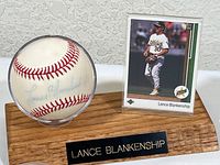 Front view of autographed baseball and rookie card on wooden display stand with nameplate